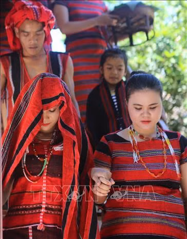 Mẹ cô dâu (bên phải) dắt tay con gái xuống cầu thang để tiễn về nhà chồng trong ngày cưới. Ảnh: Hồ Cầu-TTXVN