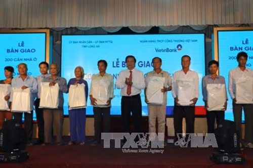 Bí thư tỉnh ủy Long An và lãnh đạo UBND tỉnh, Ngân hàng Viettinbank trao quà cho hộ nghèo. Ảnh: Thanh Bình - TTXVN