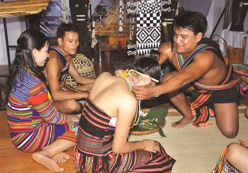 Ông mai đeo chuỗi vòng cườm cho cô dâu