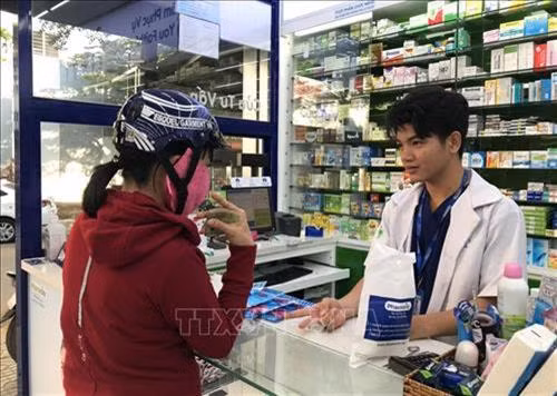 Người dân đến mua khẩu trang y tế và dung dịch rửa tay sát khuẩn tại một cửa hàng thuộc hệ thống Pharmacity. Ảnh: Đinh Hằng - TTXVN