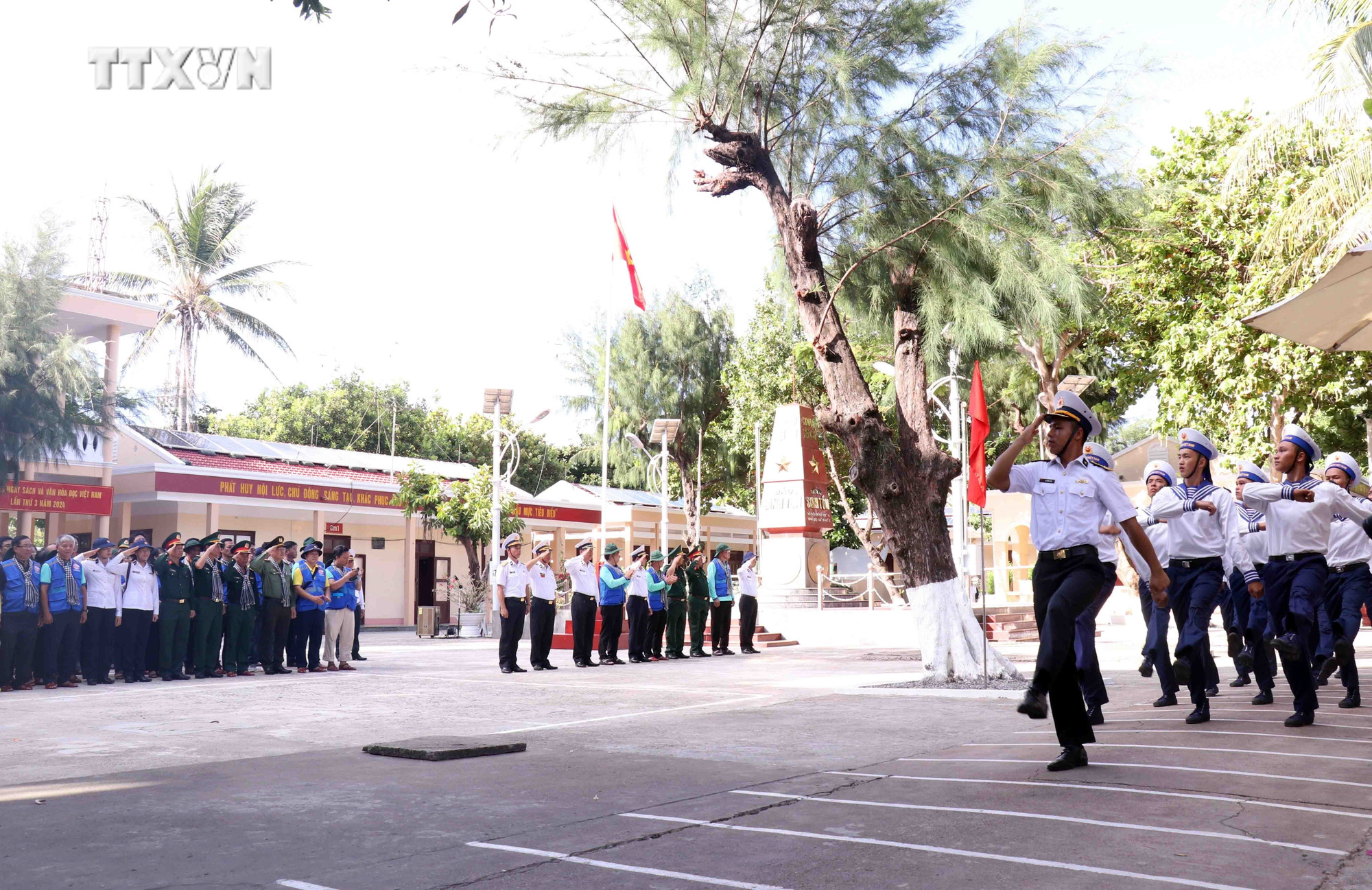 Cán bộ, chiến sĩ đảo Sinh Tồn trong buổi lễ chào cờ cùng đoàn đại biểu đoàn công tác số 12. Ảnh: Xuân Khu-TTXVN vna_potal_mang_tinh_yeu_den_truong_sa_nhan_niem_tin_khi_tro_ve__7380963.jpg