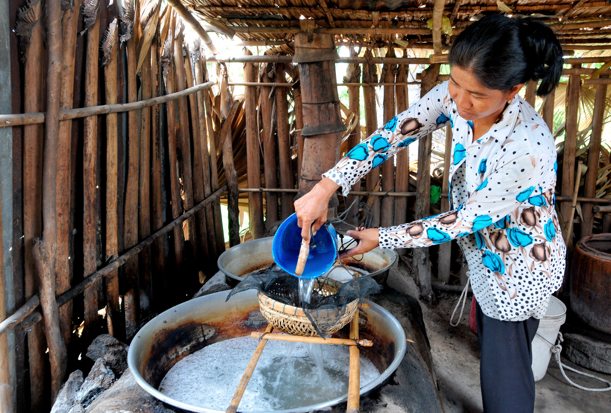 Nước thốt nốt được người dân nấu thành đường hoàn toàn bằng phương pháp thủ công với chiếc chảo gang đặt trên lò đất đỏ lửa. 10 lít nước thốt nốt sẽ được nấu trong vài giờ để tạo ra 1kg đường ngọt thanh tự nhiên, không sử dụng phụ gia. Ảnh: An Hiếu - Báo ảnh Dân tộc và Miền núi HIE_7865.JPG