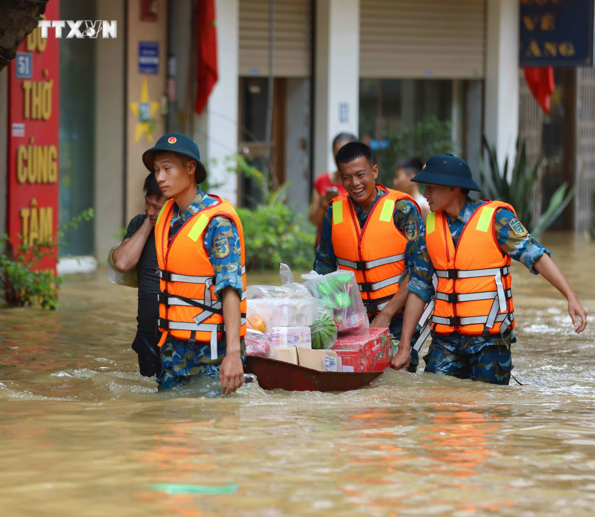 Lực lượng quân đội, công an, dân quân giúp dân xã Bát Tràng, huyện Gia Lâm, Hà Nội di chuyển ra khỏi vùng ngập lụt. Ảnh: Thanh Tùng - TTXVN vna_potal_sang_ngoi_sac_ao_linh_noi_lu_du_7593081.jpg
