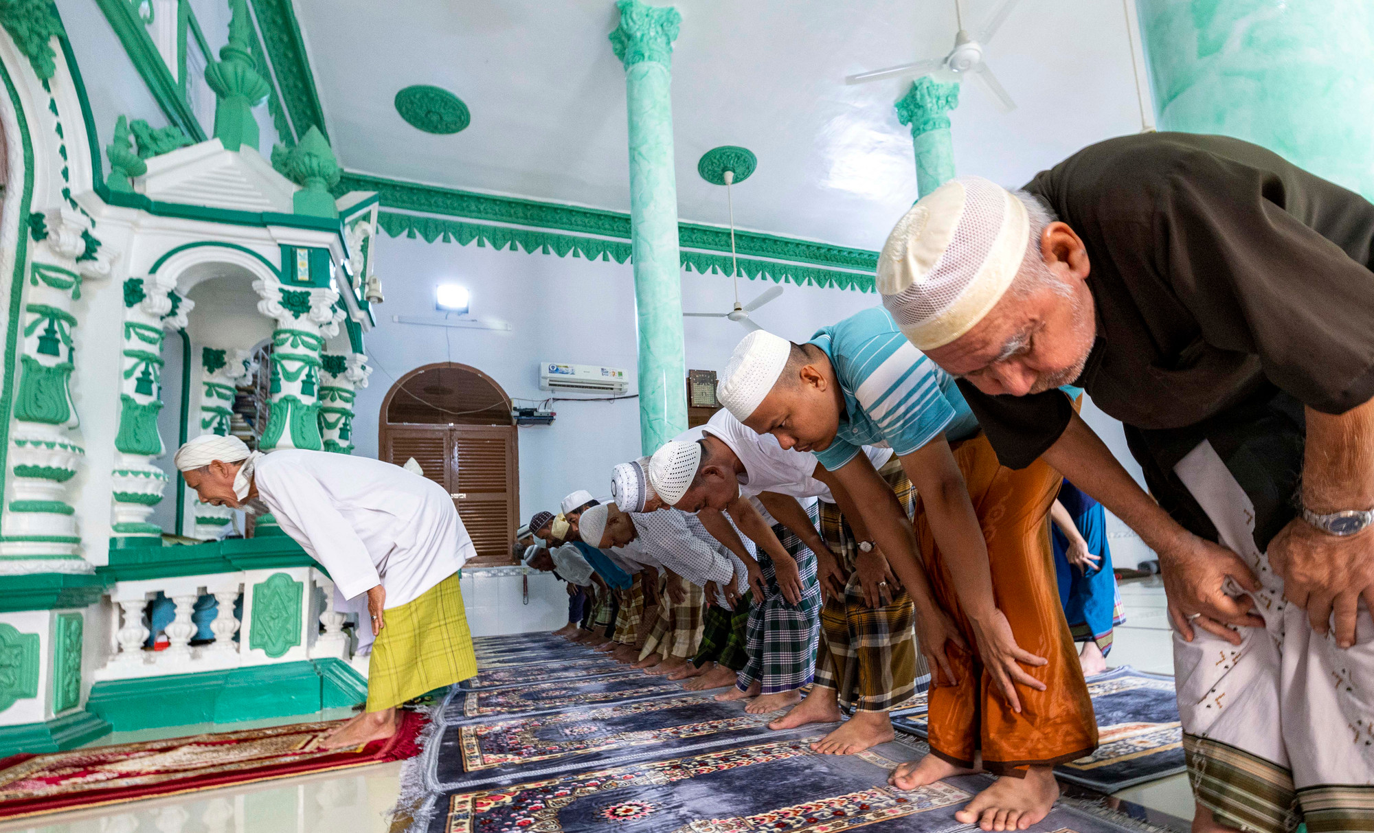 Khác với các tôn giáo khác, thánh đường Hồi giáo tuyệt đối không có bàn thờ, đèn nến, hương hoa, tranh, tượng, trên các bức tường chỉ có những câu Kinh Koran bằng chữ Ả Rập. Vào lễ, chức sắc mặc áo achuba màu trắng, có cổ cao, chất liệu vải dày, được mặc cùng với xà rông. Người Chăm sống quần tụ hòa thuận, đùm bọc lẫn nhau theo từng xóm, mỗi xóm đều có thánh đường và có 1 vị giáo cả đứng đầu. Với phương châm sống “Tốt đời, đẹp đạo”, các chức sắc, giáo cả luôn tuyên truyền cho tín đồ về tinh thần yêu nước, đoàn kết, gắn bó, đồng hành với dân tộc. Ảnh: Trọng Chính TC 04 3G0A9167.jpg