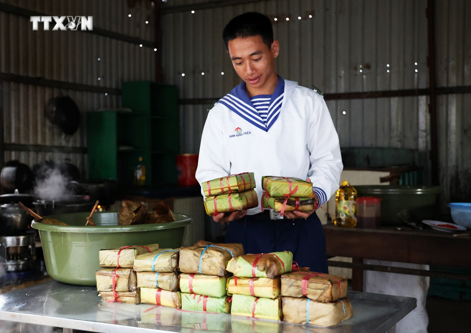 Chiến sĩ Phan Xuân Thiện bên các cặp bánh chưng mới vớt. Ảnh: Hồng Đạt - TTXVN vna_potal_quan_dan_o_truong_sa_thi_goi_banh_chung_don_tet_7211450.jpg