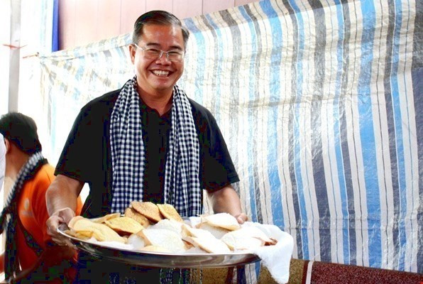 Khách du lịch thích thú với món bánh bò nướng thốt nốt khi đến An Giang. Ảnh: TTXVN phát thotnot1.jpeg