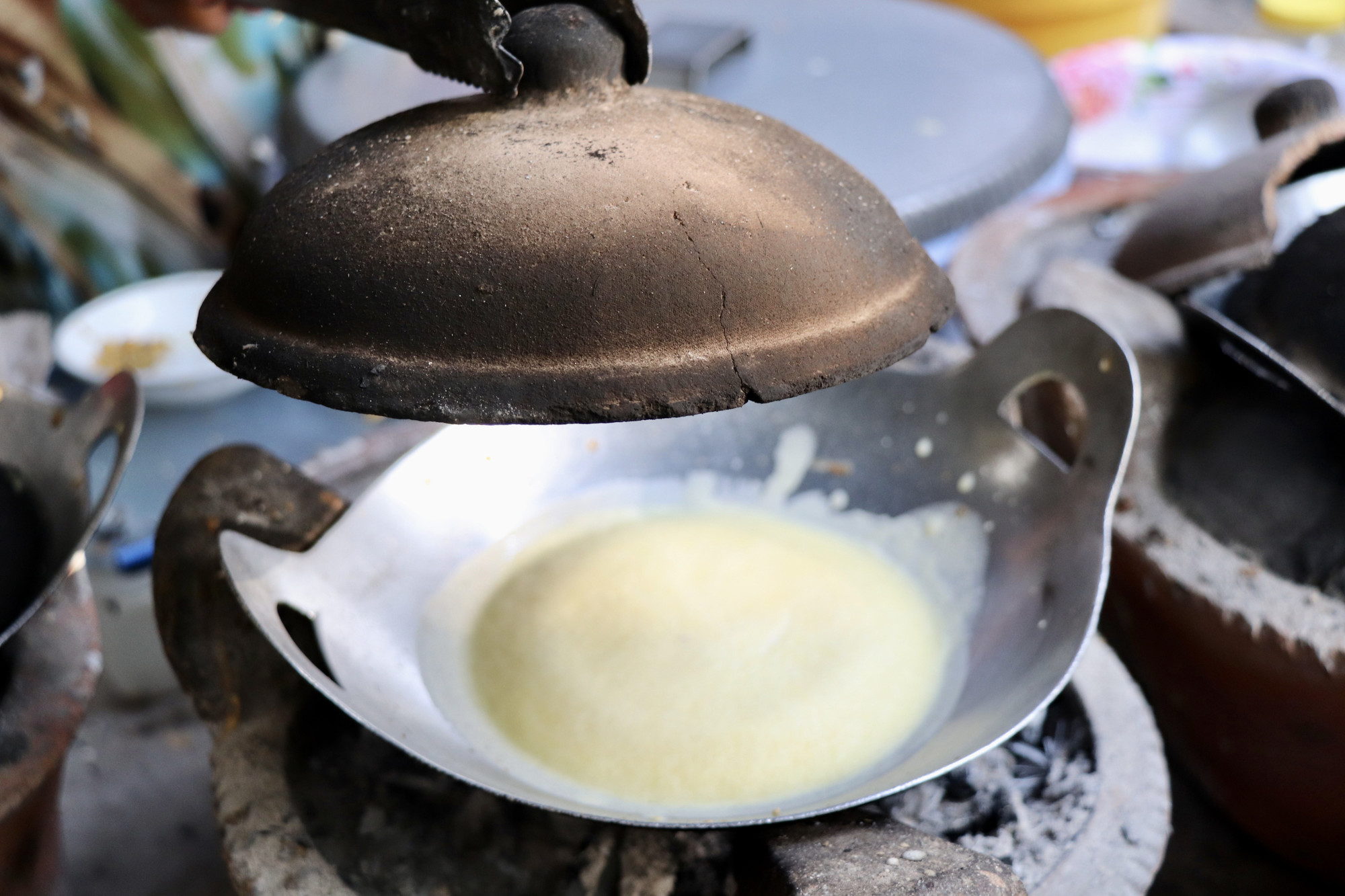 Bánh bò Thốt nốt nướng trên bếp lửa than đậy bằng nắp đất nung. Ảnh: Thanh Sang – TTXVN thotnot2.jpeg