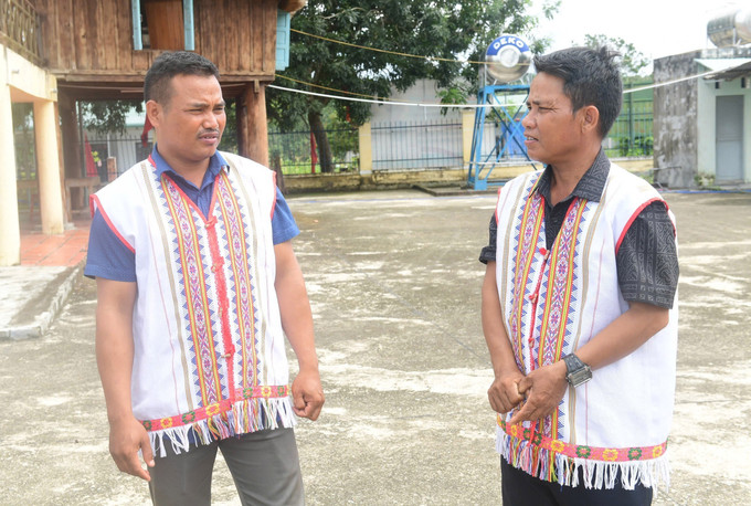 Bí thư Chi bộ kiêm Trưởng thôn làng Le A Thái (đứng giữa) thường xuyên phối hợp với các cán bộ tuyên truyền, vận động bà con bảo tồn nét văn hóa truyền thống. Ảnh: TTXVN phát