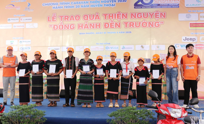 Các nhà tài trợ tặng học bổng cho học sinh hiếu học, có hoàn cảnh khó khăn trên địa bàn xã Đồng Nai, huyện Bù Đăng, tỉnh Bình Phước. Ảnh: Nhật Bình/TTXVN binh-phuoc-1525.jpg