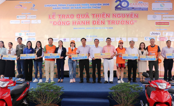 Các nhà tài trợ trao bảng tượng trưng tặng các phần quà đến học sinh hiếu học, có hoàn cảnh khó khăn trên địa bàn xã Đồng Nai. Ảnh: Nhật Bình/TTXVN binh-phuoc2-1525.jpg