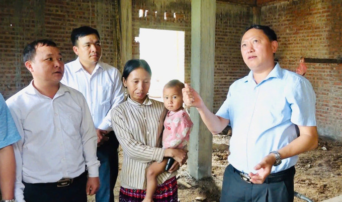 Bí thư Huyện ủy Trạm Tấu Giàng A Vừ kiểm tra công tác xóa nhà tạm, nhà đột nát trên địa bàn. Ảnh: TTXVN phát nha-1625.jpg