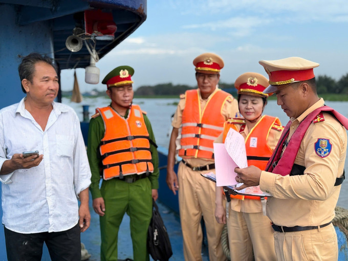 Lực lượng Cảnh sát đường thủy Long An kiểm tra chủ phương tiện vận chuyển khoáng sản trên sông Vàm Cỏ Đông. Ảnh: TTXVN phát long-an-1625.jpg