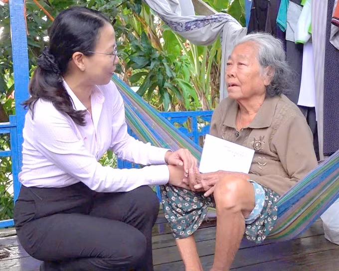 Bà Quách Tố Giang, Bí thư Đảng ủy, Chủ tịch HĐND xã An Phú (An Giang) thăm hỏi, trao tiền hỗ trợ cho người dân có nhà bị ảnh hưởng bởi mua lớn kèm dông lốc.