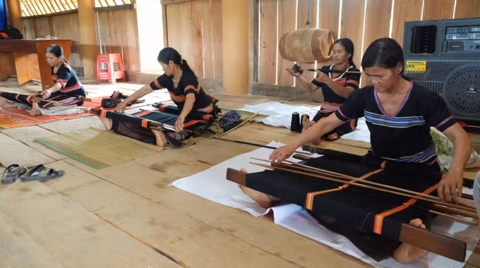 Phụ nữ Giẻ - Triêng ở thôn Ri Mẹt, xã Đăk Môn, tỉnh Quảng Ngãi bên khung dệt thổ cẩm truyền thống.