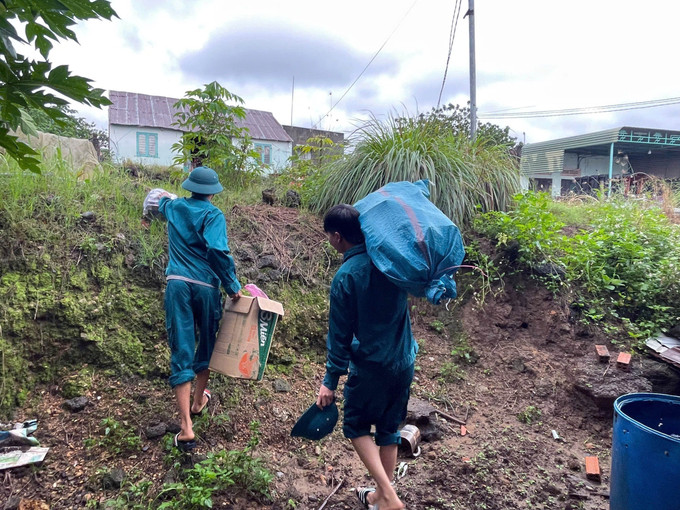 Lực lượng dân quân hỗ trợ người dân di chuyển đồ đạc khỏi vùng ngập lụt ven sông Krông Nô, tỉnh Lâm Đồng. Ảnh: TTXVN phát