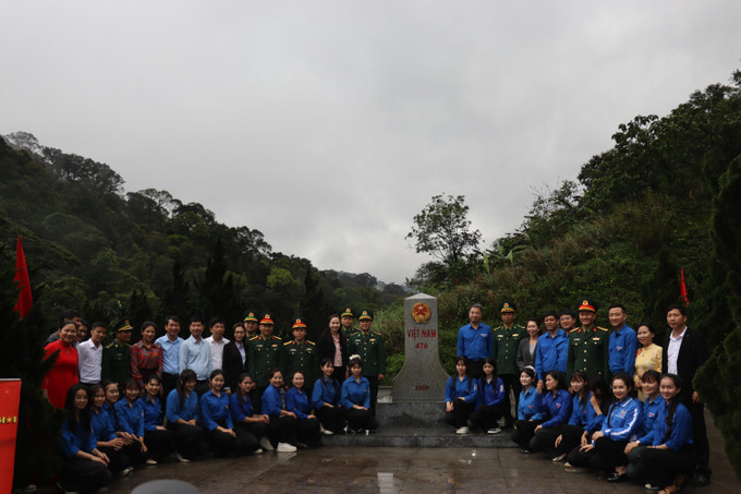 Đại biểu và đoàn viên thanh niên chụp ảnh lưu niệm bên Cột mốc 476 biên giới Việt Nam - Lào.