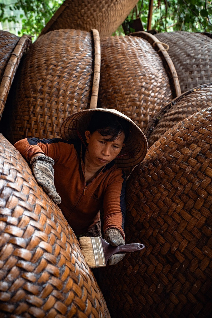Người thợ thực hiện công đoạn quét dầu rái cho thúng chai. thung5-25725.jpg