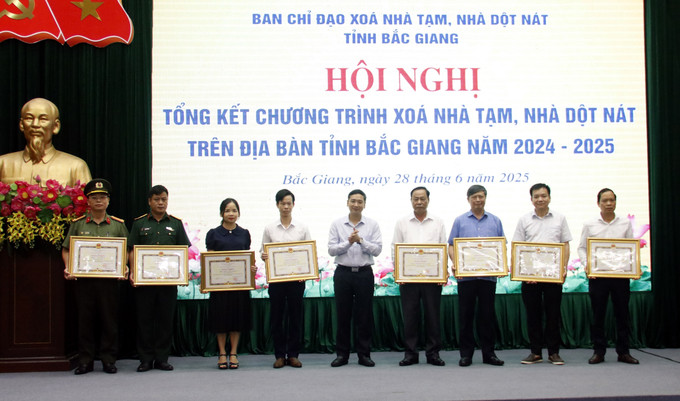 Chủ tịch UBND tỉnh Bắc Giang Nguyễn Việt Oanh trao bằng khen cho các tập thể có thành tích xuất sắc trong Chương trình xóa nhà tạm, nhà dột nát trên địa bàn tỉnh. nha-28625.jpg