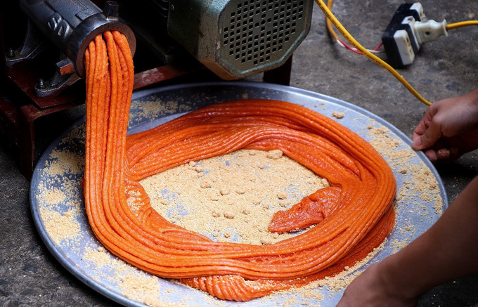 Xôi gấc làm bánh giầy được xay nhuyễn, có màu cam đỏ.