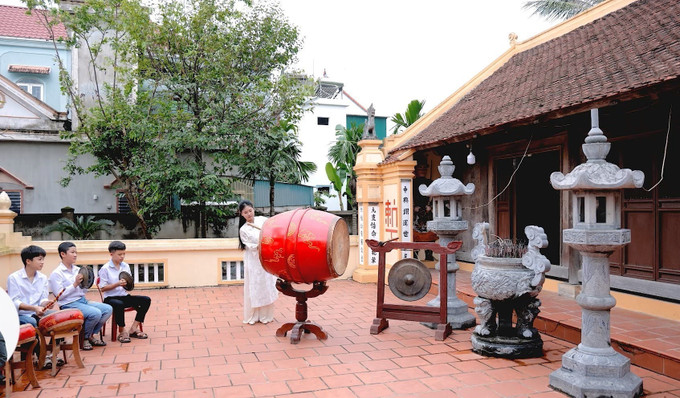 Học sinh Trường THCS Phan Đăng Lưu đánh trống tế tại nhà thờ dòng họ Phan Tất (xã Yên Thành, Nghệ An). Ảnh: TTXVN phát