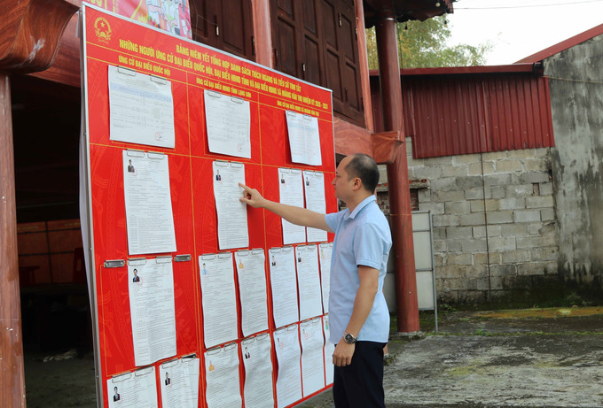 Cử tri tìm hiểu danh sách những người ứng cử tại nhà văn hóa thôn Nhân Hòa, xã biên giới Hoàng Văn Thụ, tỉnh Lạng Sơn.