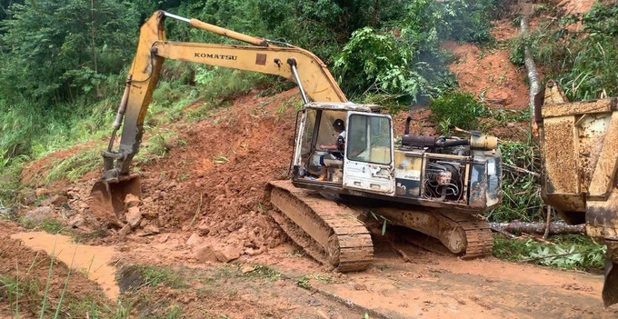 Lực lượng chức năng huy động phương tiện và nhân lực nhanh chóng khắc phục các điểm sạt lở trên tỉnh lộ 674. Ảnh: TTXVN phát sat-lo-24925.jpg