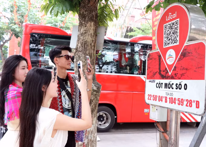 Du khách quét QR tại Km0 Hà Giang tim hiểu thông tin du lịch.
