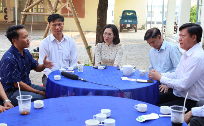 Chủ tịch UBND xã Nha Bích Nguyễn Hồng Thái (đầu tiên, bên phải) lắng nghe kiến nghị của người dân. Ảnh: Đậu Tất Thành/TTXVN