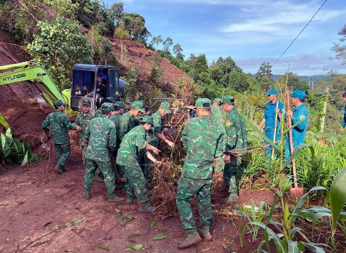 Lực lượng Đồn Biên phòng Cửa khẩu Thuận An hỗ trợ thu dọn đất, đá trên tuyến đường huyết mạch tại thôn Thuận Nam, xã Thuận An, tỉnh Lâm Đồng. Ảnh: TTXVN phát Lực lượng Đồn Biên phòng Cửa khẩu Thuận An hỗ trợ thu dọn đất, đá trên tuyến đường huyết mạch tại thôn Thuận Nam, xã Thuận An, tỉnh Lâm Đồng. Ảnh: TTXVN phát