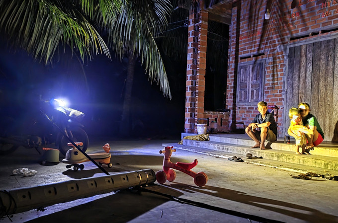 Người dân xã Xuân Cảnh (tỉnh Đắk Lắk) dùng đèn xe máy thắp sáng do mất điện (ảnh chụp tối 12/11).