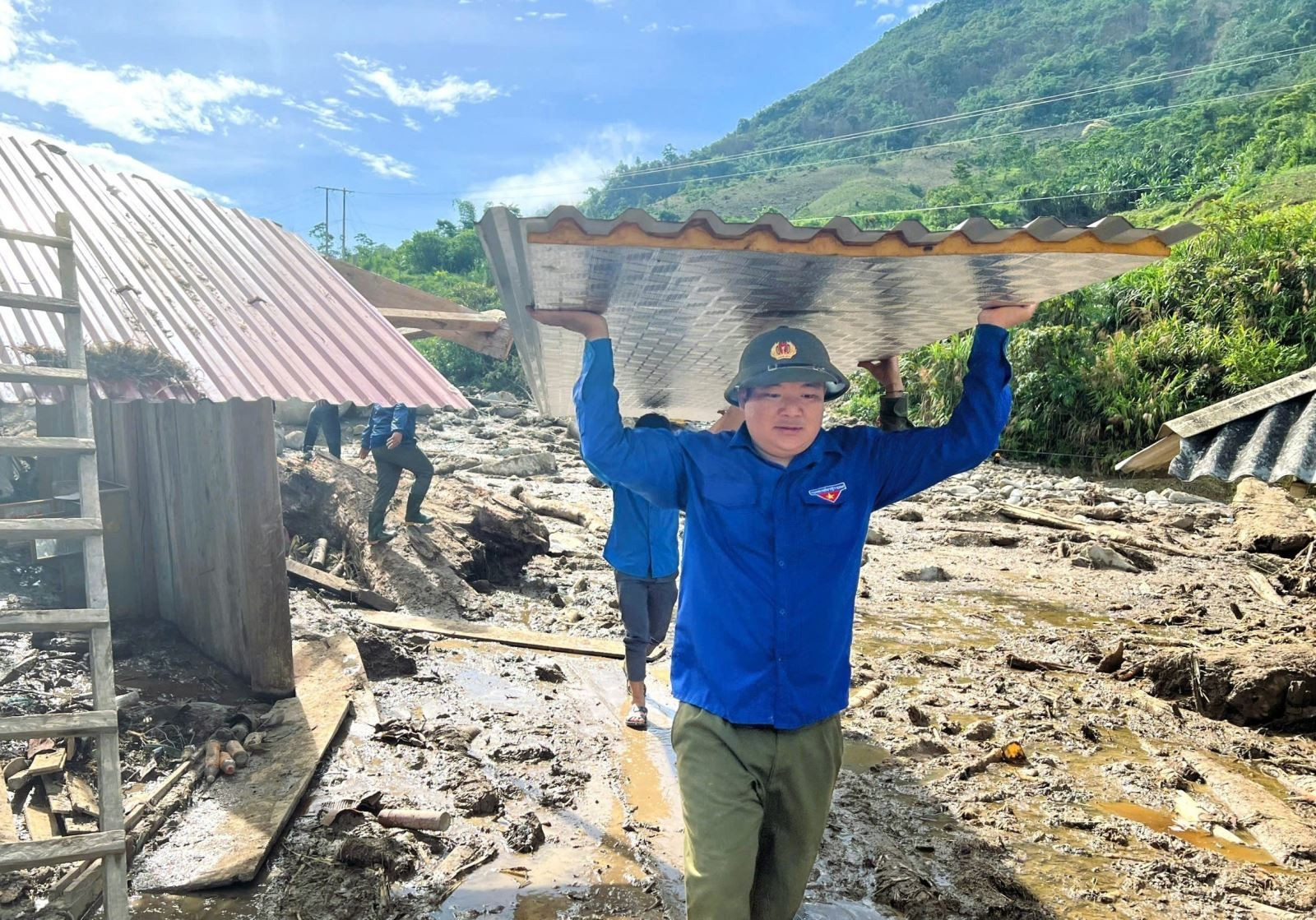 Đoàn viên thanh niên Huyện đoàn Tương Dương (Nghệ An) tham gia hỗ trợ, giúp đỡ người dân biên giới xã Nhôn Mai (huyện Tương Dương) khắc phục hậu quả sau lũ quét. Ảnh: TTXVN phát Chú thích ảnh