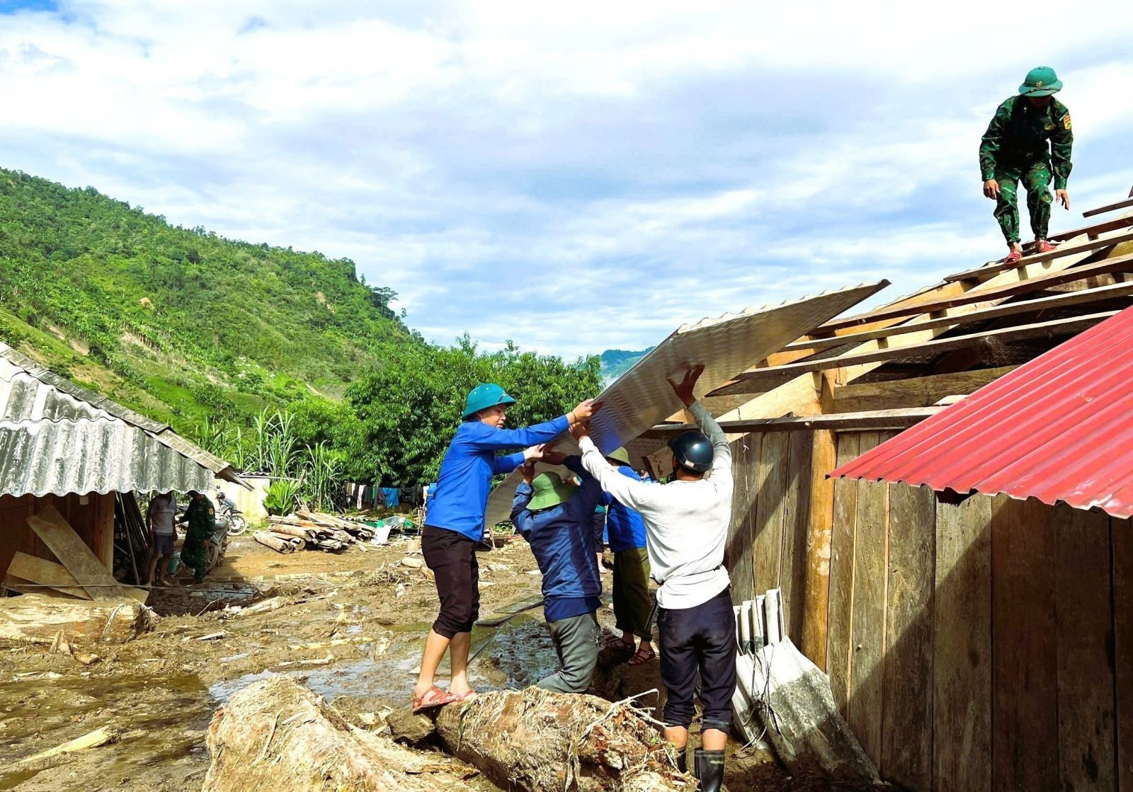 Lực lượng Bộ đội Biên phòng Nghệ An, đoàn viên thanh niên huyện Đoàn Tương Dương và người dân hỗ trợ, giúp đỡ dân bản sửa chữa nhà ở bị thiệt hại sau lũ quét. Ảnh: TTXVN phát Chú thích ảnh