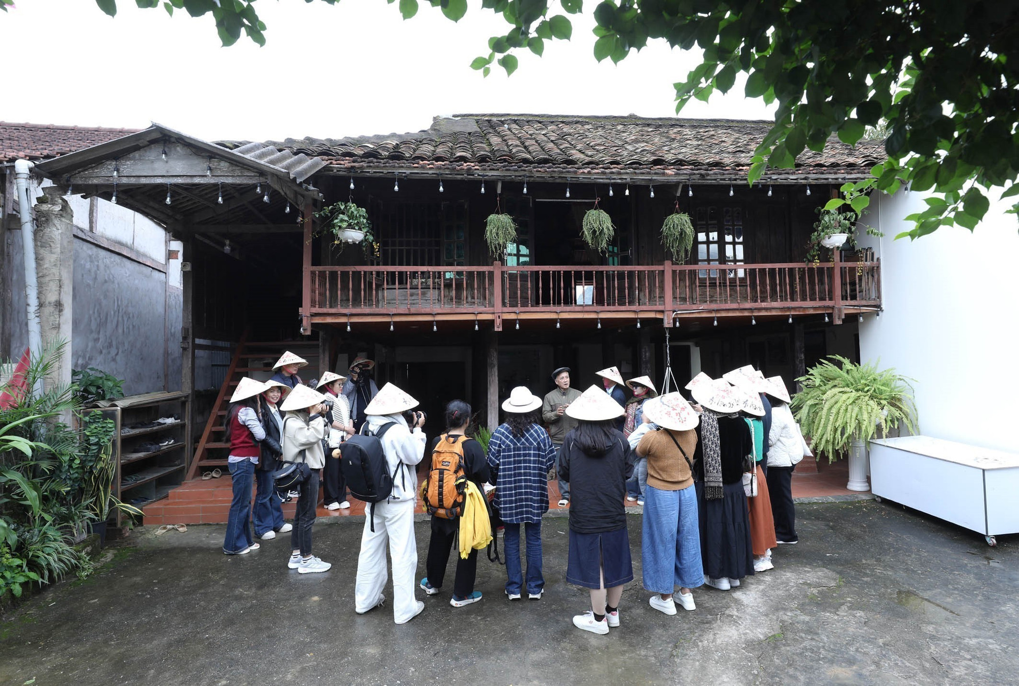Du khách tìm hiểu về nhà sàn tại Homestay Dương Công Chài, Làng du lịch cộng đồng Quỳnh Sơn, xã Bắc Sơn, tỉnh Lạng Sơn.