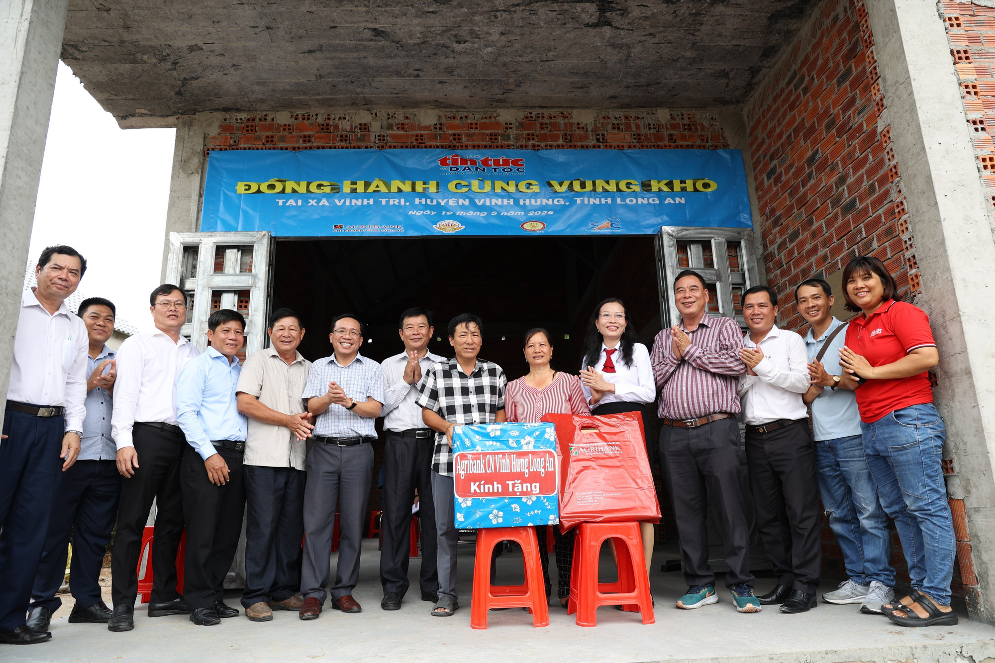 Đại diện Báo Tin tức và Dân tộc (TTXVN) và các nhà tài trợ bàn giao nhà cho người dân khó khăn thuộc huyện biên giới Vĩnh Hưng, tỉnh Long An (cũ). Ảnh: Bùi Giang/TTXVN tintuc.jpg