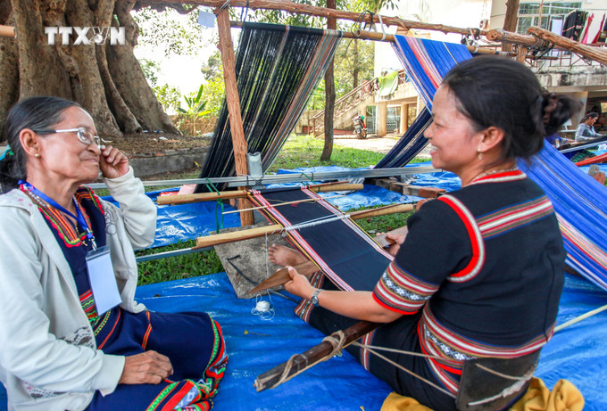 Nghệ nhân Y Tủi (phải), người Bahnar, xã Kroong, thành phố Kon Tum, tỉnh Kon Tum, mang nghề dệt thổ cẩm đến trình diễn tại lễ hội. Ảnh: Khoa Chương - TTXVN vna_potal_van_hoa_soi_duong_giu_gin_van_hoa_det_tho_cam_cua_nguoi_bahnar_o_tay_nguyen_7674982.jpg