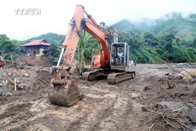 Máy xúc được huy động để san gạt bùn đất giúp nhân dân xã Chiềng Nơi, huyện Mai Sơn đi lại thuận tiện sau mưa lũ. Ảnh: Quang Quyết – TTXVN vna_potal_tich_cuc_trien_khai_cong_tac_khac_phuc_hau_qua_mua_lu_tai_son_la_7545920.jpg