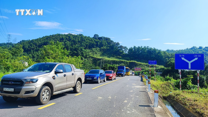 Lực lượng chức năng tổ chức phân luồng cho các phương tiện tham gia giao thông. Ảnh: Quốc Khánh - TTXVN vna_potal_an_toan_giao_thong_sat_lo_dat_da_gay_ach_tac_duong_len_sa_pa_lao_cai_7496426.jpg