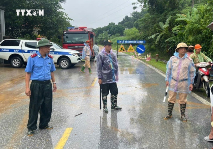 Cán bộ, chiến sỹ Công an tỉnh Hà Giang và các lực lượng chức năng phân luồng giao thông trên tuyến Quốc lộ 2. Ảnh: TTXVN phát vna_potal_vu_sat_lo_nghiem_trong_tai_ha_giang_huy_dong_toi_da_luc_luong_tim_kiem_nan_nhan_mat_tich_7624463.jpg
