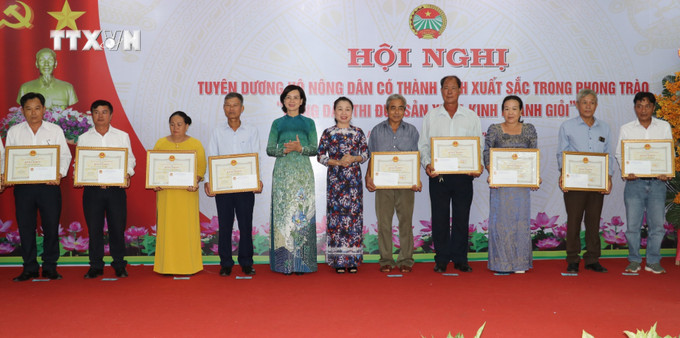 Phó Chủ tịch UBND tỉnh Bình Phước Trần Tuyết Minh (trái) và Trưởng ban Dân vận Tỉnh Uỷ Bình Phước Lê Thị Xuân Trang (phải) tặng Bằng khen của Chủ tịch UBND tỉnh Bình Phước cho các hộ nông dân nông dân sản xuất kinh doanh giỏi cấp tỉnh năm 2024. Ảnh: Nhật Bình – TTXVN. vna_potal_binh_phuoc_tuyen_duong_112_ho_nong_dan_nong_dan_san_xuat_kinh_doanh_gioi_cap_tinh_nam_2024__7478671.jpg