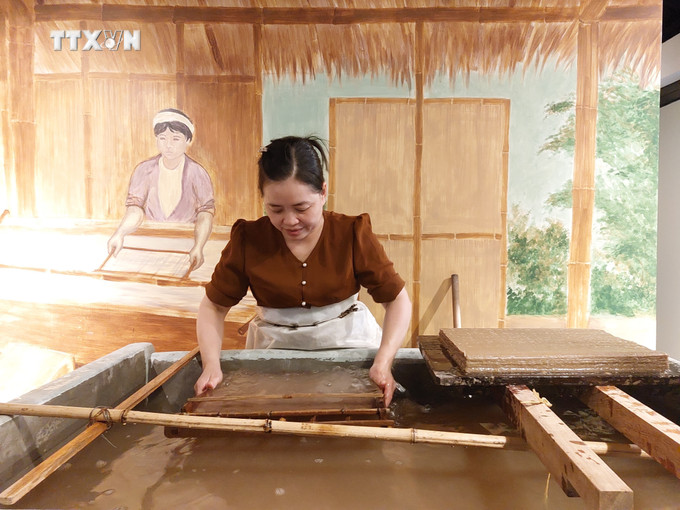 Chị Nguyễn Thị Độ đang thực hiện công đoạn xeo giấy Dó. Ảnh: Minh Ngọc - TTXVN vna_potal_phuc_dung_mo_hinh_lang_nghe_giay_do_vung_buoi_xua_7374139.jpg