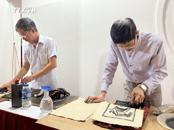 Thực hiện công đoạn in tranh trên giấy Dó. Ảnh: Minh Ngọc - TTXVN vna_potal_phuc_dung_mo_hinh_lang_nghe_giay_do_vung_buoi_xua_7374141.jpg