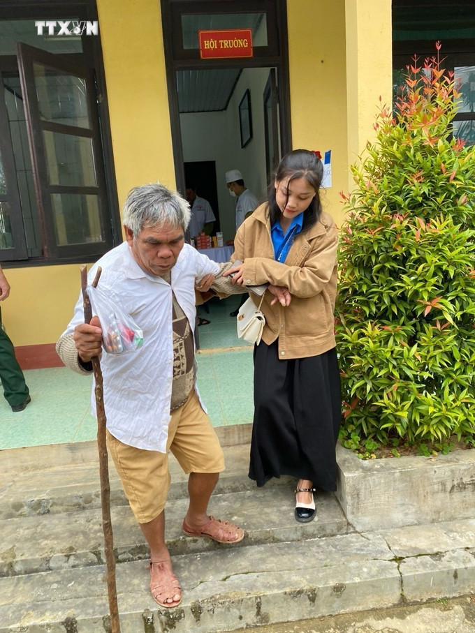 Đoàn viên hỗ trợ người cao tuổi đến khám và nhận thuốc miễn phí trong chương trình "Tháng Ba biên giới" năm 2024. Ảnh: TTXVN phát vna_potal_dau_an_mau_ao_xanh_noi_vung_nui_cao_xu_hue_7288229.jpg