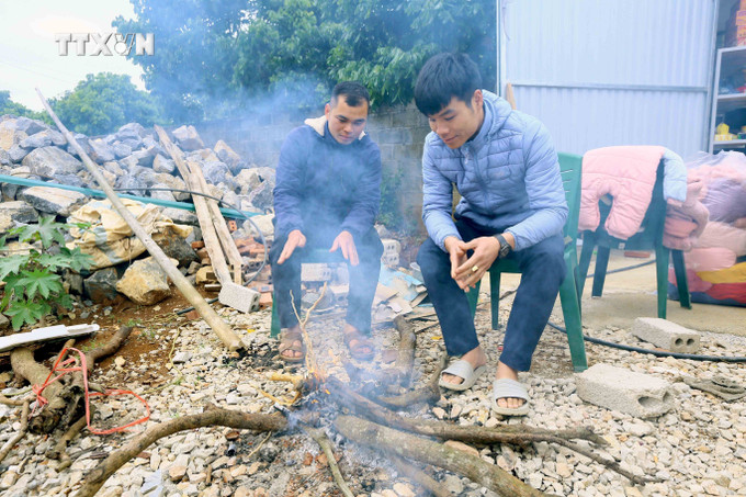 Người dân xã Chiềng Ngần, thành phố Sơn La đốt củi để sưởi ấm trong những ngày giá rét. Ảnh: Quang Quyết-TTXVN vna_potal_nhiet_do_giam_sau_anh_huong_sinh_hoat_san_xuat_cua_nguoi_dan_son_la_7193741 (1).jpg