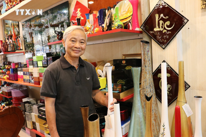 Nghệ nhân Lê Bá Linh, Phó Chủ tịch Hiệp hội Sơn mài và Điêu khắc Bình Dương, chủ cơ sở sơn mài Tư Bốn bên các sản phẩm sơn mài. Ảnh: Dương Chí Tưởng-TTXVN vna_potal_san_pham_ocop_o_dia_phuong_giu_lua_nghe_son_mai_tuong_binh_hiep_7331697.jpg