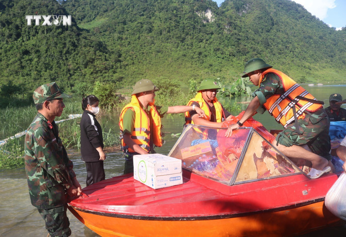 Lực lượng chức năng tiếp tế nhu yếu phẩm cho người dân các xóm bị cô lập ở xã Quang Vinh, huyện Trùng Khánh (Cao Bằng). Ảnh: Chu Hiệu-TTXVN vna_potal_con_7_xom_bi_co_lap_do_ngap_lut_tai_cao_bang__7559875.jpg