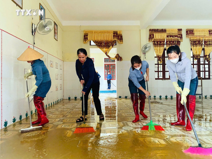 Giáo viên trường mầm non Kim Hoa (huyện Hương Sơn) dọn bùn đất trong phòng học. Ảnh: TTXVN vna_potal_ha_tinh_tap_trung_khac_phuc_hau_qua_mua_lu_7616530.jpg