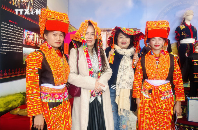Du khách tham quan hào hứng chụp ảnh lưu niệm với những cô gái Dao đến từ tỉnh Bắc Giang. Ảnh: Nguyên Linh-TTXVN vna_potal_ngay_hoi_van_hoa_cac_dan_toc_viet_nam_tai_tinh_quang_tri_nam_2024_7759533.jpg
