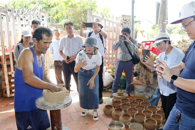 Du khách tìm hiểu cách làm gốm thủ công tại làng nghề gốm Bình Đức của người Chăm tại huyện Bắc Bình (Bình Thuận). Ảnh: Nguyễn Thanh - TTXVN vna_potal_du_lich_viet_nam_khao_sat_xay_dung_phat_trien_san_pham_du_lich_lang_nghe_va_am_thuc_binh_thuan_7414316.jpg