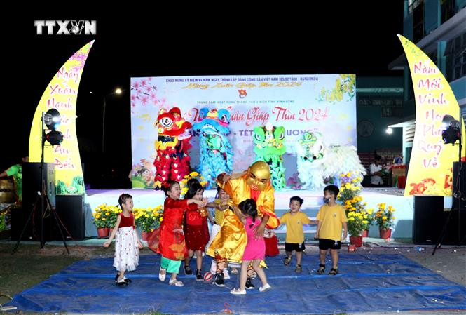 Múa Lân Sư Rồng mang đến niềm vui và tiếng cười cho các em nhỏ mỗi dịp Tết đến. Ảnh: Lê Thúy Hằng - TTXVN vna_potal_vinh_long_ron_rang_mua_lan_su_rong_ngay_xuan_7222156.jpg