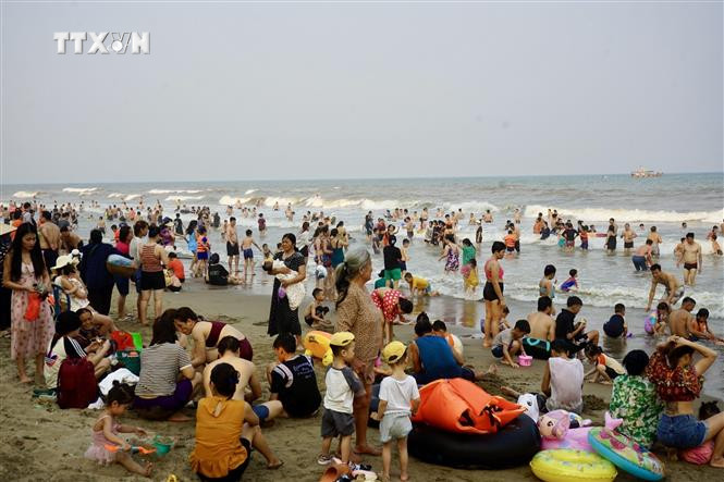 Du khách và người dân địa phương đổ về Bãi biển Sầm Sơn. Ảnh: Hoa Mai - TTXVN vna_potal_du_khach_va_nguoi_dan_thanh_hoa_do_ra_bien_giai_nhiet_7349684.jpeg